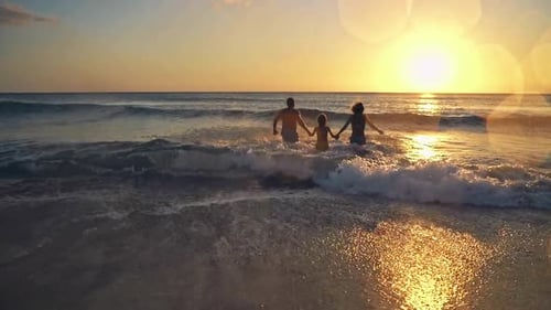Happy Family having Fun on Summer Vacation. Father, Mother and Child Playing in Sea