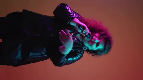 Singer Performing with Microphone Under Colored Lights
