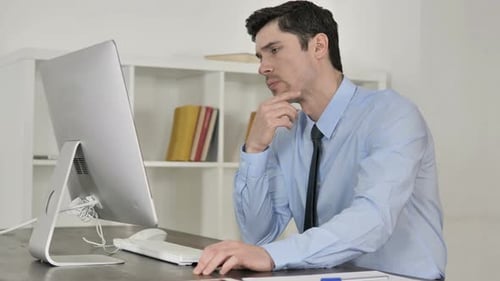 Nachdenklicher Geschäftsmann denkt bei der Arbeit am Computer
