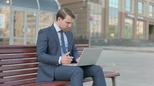 Man Works on Laptop Outdoors, Celebrates Success