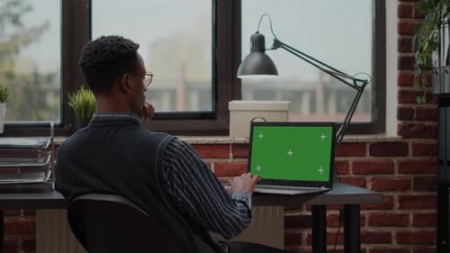 Business Man Working with Laptop and Green Screen on Display