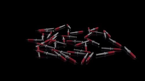 Medical Syringes with Red Liquid on Black Background Loop