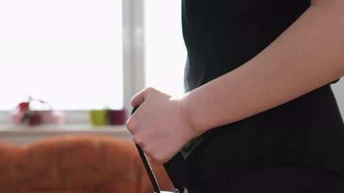 Mulher com roupa esportiva preta fazendo exercícios usando o expansor no stepper