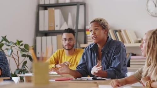College Students Having Discussion with Senior Professor in Classroom