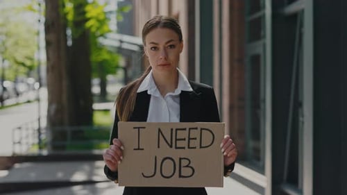 Fired Woman Standing with I Need Job Banner Outdoors