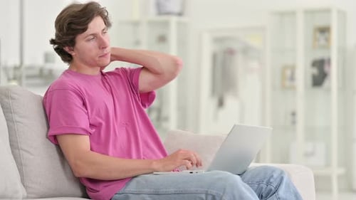 Young Adult Working From Home Massages Neck