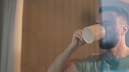 Bearded Man Drinking from Mug Indoors