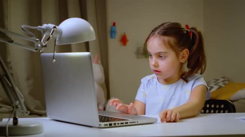 Little Girl Studying at an Online School on a Laptop