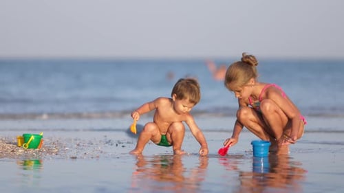 Children Playing with Toys on a Sandy Beach