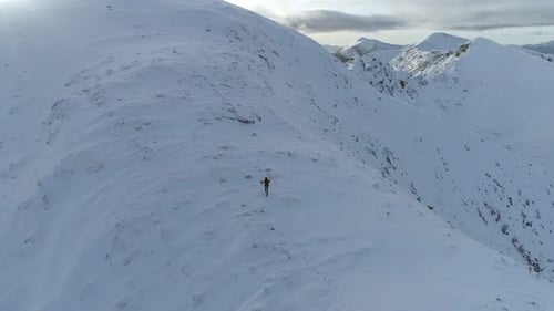 Mountain Climber Almost at the Summit of a Snowy Mountain
