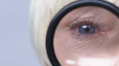 Woman's Eye Examined Under Magnifying Glass Close Up