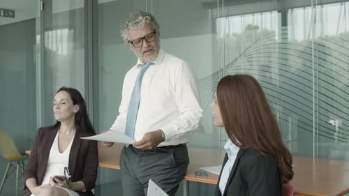Team Discussing Charts and Data in a Bright Office