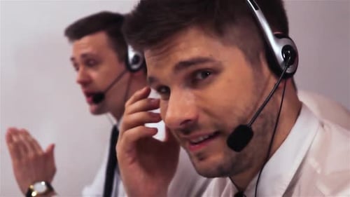 Two Businessmen with Headsets Talking on Voice Call Centre Technical Support
