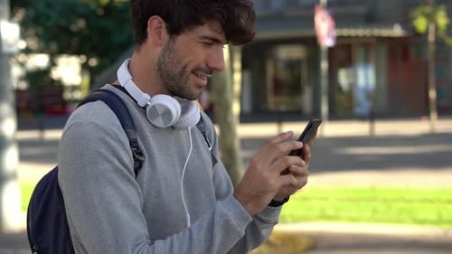 Man with backpack and smartphone in the city