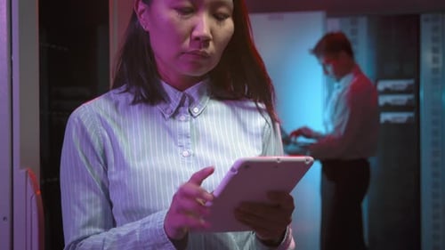 Asian Woman with Tablet Posing in Data Center