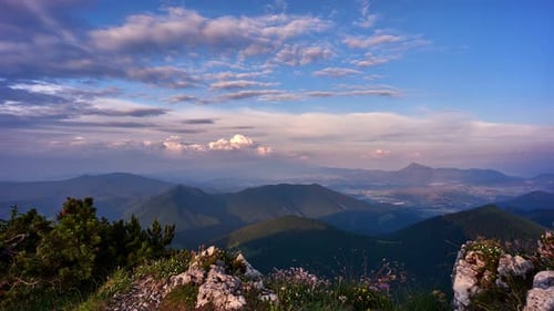 Colorful clouds at sunset over summer mountain landscape. 4K video