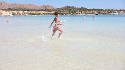 Woman Running on Tropical Beach on a Sunny Day