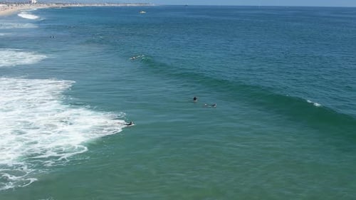 Aerial View of Surfers Catching Waves