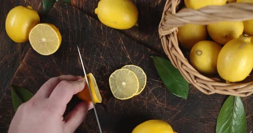 Lemon Being Sliced on Wooden Cutting Board