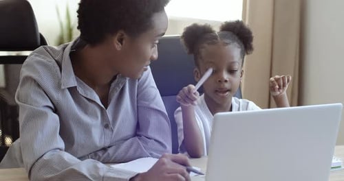 Woman and Girl Working on Laptop at Home