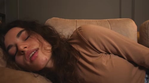 Retrato de primer plano de una atractiva mujer joven descansando en el sofá, una mujer sana y tranquila relajándose
