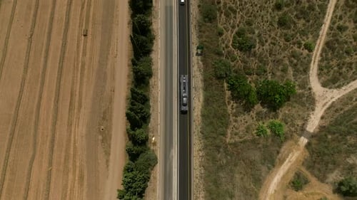 Tow truck carrying a single car on a rural highway, Aerial follow footage.