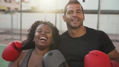 Smiling Couple Wearing Boxing Gloves on Sports Court