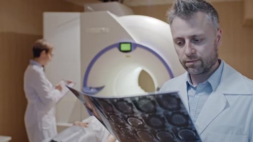 Doctor Inspecting Tomography Scan of Brain