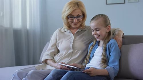 Woman and Child Looking at Tablet Together