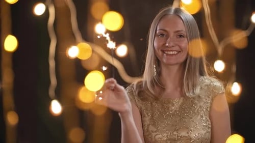 Woman Celebrates with Sparkler in Festive Setting