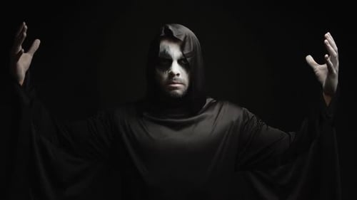 Man in Hooded Robe Poses with Dark Makeup