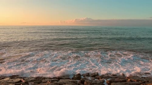 Waves Crashing on Rocky Beach at Sunrise