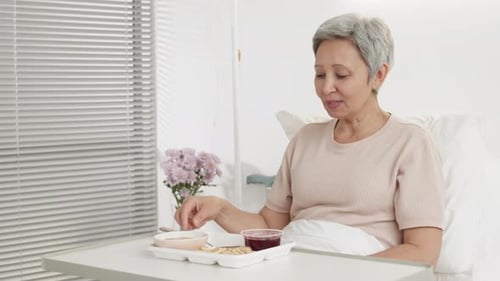 Woman Eating Meal in Hospital Bed