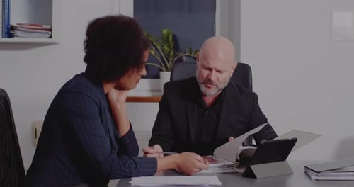 Two Colleagues Discuss Business at Office Table