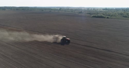 Countryside and Agriculture, Farm Tractors Plow the Earth in Field, Dust in the Field, View From