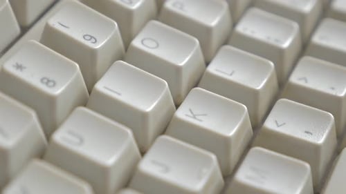 Panning over retro style beige keyboard close up 4K 3840X2160 UHD footage - Old beige white keyboard