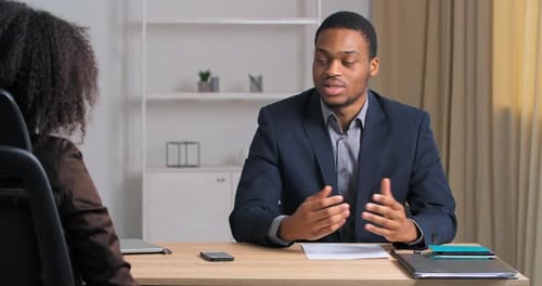Un homme d'affaires afro-américain en costume officiel interviewé dans une société de marketing informatique moderne