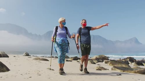 Couple Hiking on Beach with Mountains and Masks
