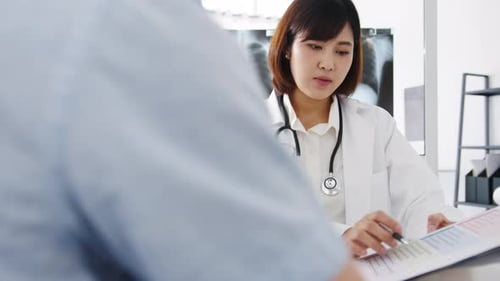 Female Doctor Discusses Paperwork with Patient