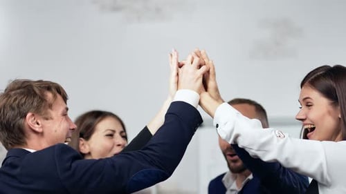 Cheerful Business Team High-Fiving in the Office