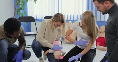 Adults Learning Infant CPR Skills in Training Class