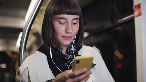 Portrait of Beautiful Young Woman in Headphones Riding in Public Transport, Listen Music and