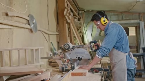 Carpenter Working with Bandsaw in Workshop
