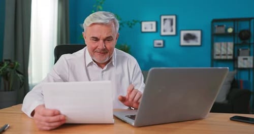 Mature Man Working At Home Office With Laptop