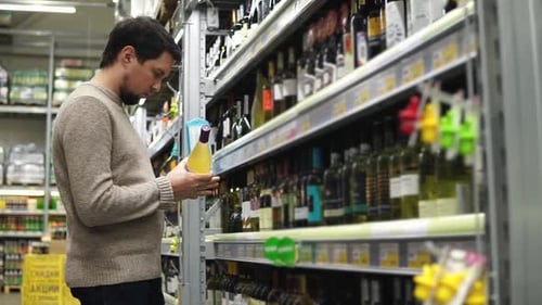 Man Shopping for Wine in Supermarket Liquor Aisle