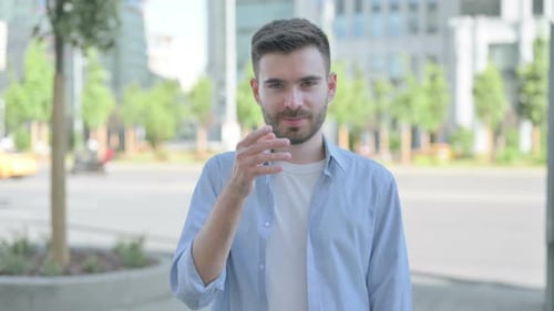 Man Beckoning Forward on City Street