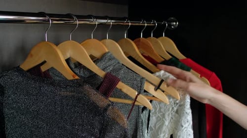 Woman Choosing Shirt from Wardrobe in Closet