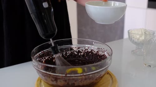 Adding Eggs to Baking Mixture with Electric Mixer