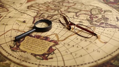 Magnifying Glass and Eyeglasses Over Antique Map