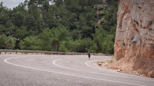Running outdoors. Young active sportive woman running on empty speedway in mountains.